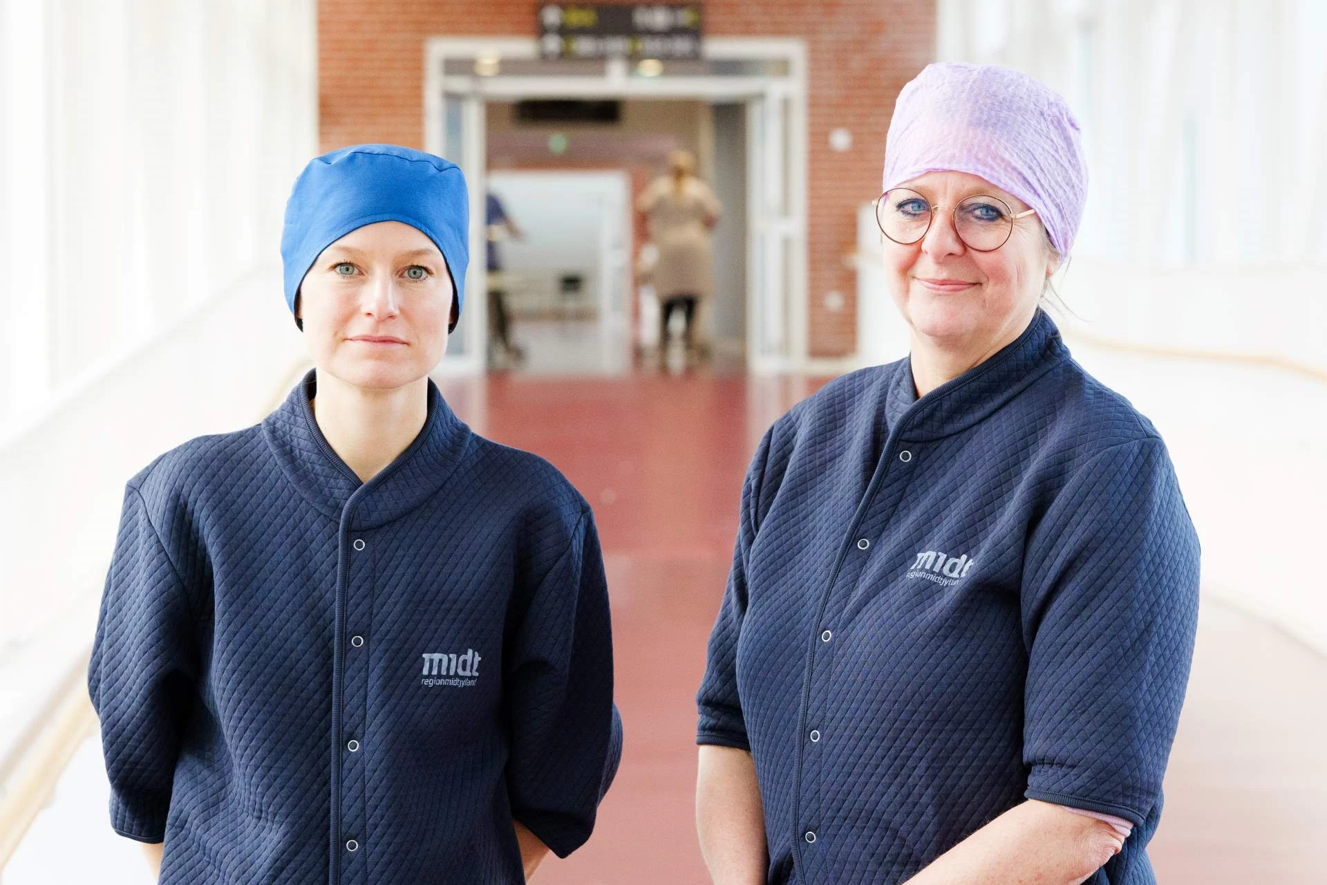 To af arbejdsgruppens medlemmer viser henholdsvis en flergangs og engangskosakhue frem.